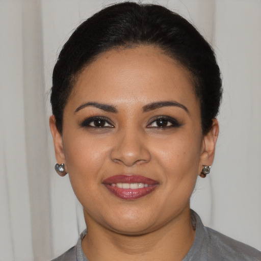 Joyful latino young-adult female with short  black hair and brown eyes