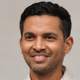 Joyful latino young-adult male with short  black hair and brown eyes