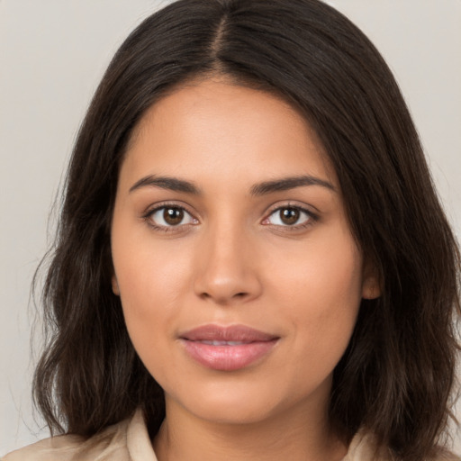 Joyful latino young-adult female with long  brown hair and brown eyes