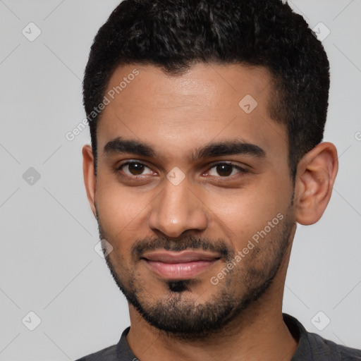 Joyful black young-adult male with short  black hair and brown eyes