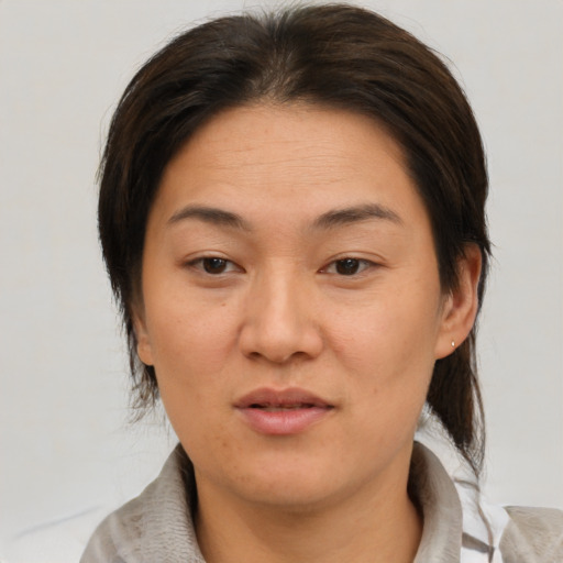 Joyful asian adult female with medium  brown hair and brown eyes