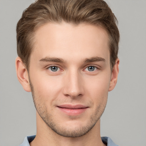 Joyful white young-adult male with short  brown hair and grey eyes