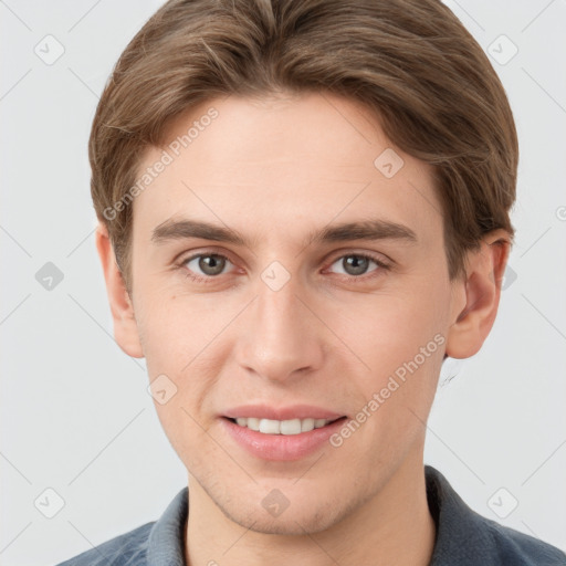 Joyful white young-adult male with short  brown hair and grey eyes