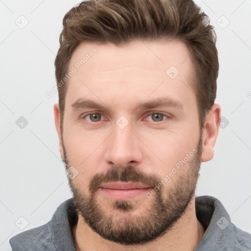 Joyful white young-adult male with short  brown hair and grey eyes