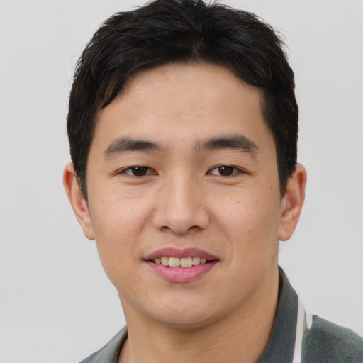Joyful asian young-adult male with short  brown hair and brown eyes