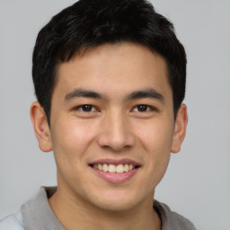 Joyful asian young-adult male with short  brown hair and brown eyes