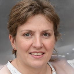 Joyful white adult female with medium  brown hair and blue eyes