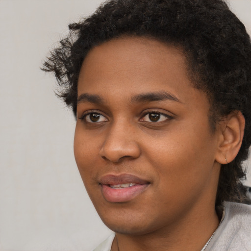 Joyful black young-adult female with short  black hair and brown eyes