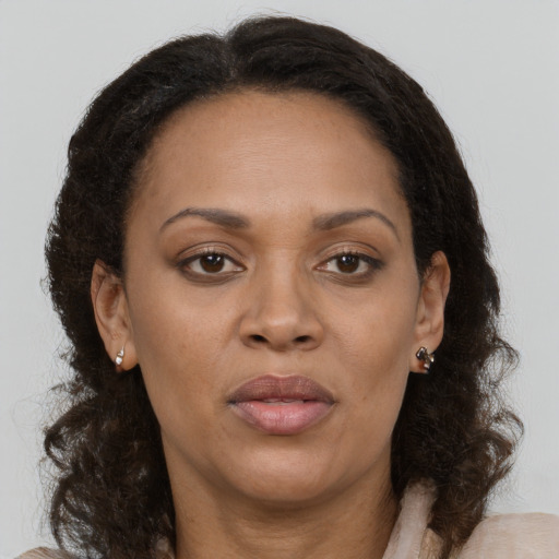 Joyful black adult female with medium  brown hair and brown eyes