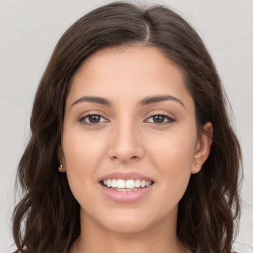 Joyful white young-adult female with long  brown hair and brown eyes