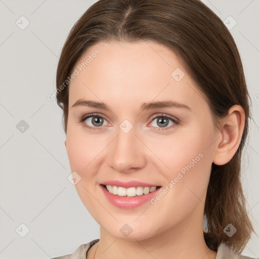 Joyful white young-adult female with medium  brown hair and grey eyes