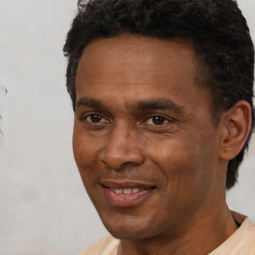 Joyful black adult male with short  brown hair and brown eyes