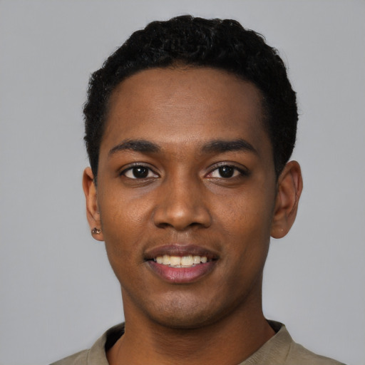 Joyful black young-adult male with short  black hair and brown eyes