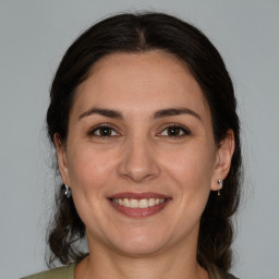 Joyful white adult female with medium  brown hair and brown eyes