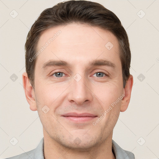 Joyful white young-adult male with short  brown hair and grey eyes