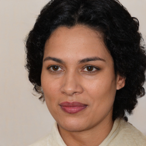 Joyful latino adult female with medium  brown hair and brown eyes