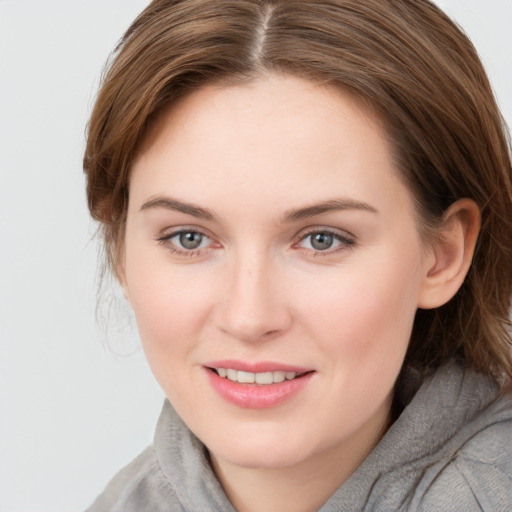 Joyful white young-adult female with medium  brown hair and grey eyes