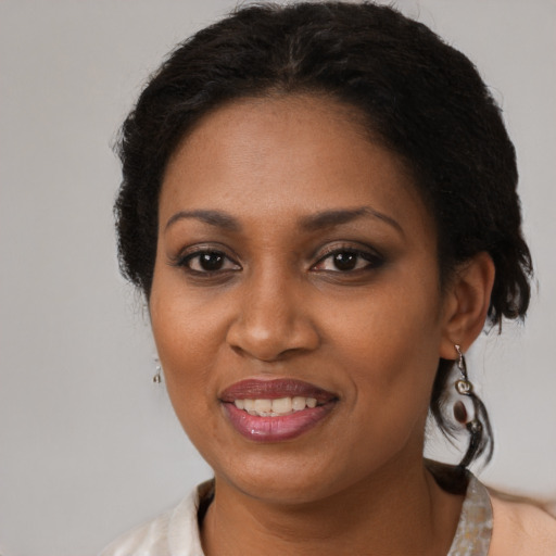 Joyful black adult female with medium  brown hair and brown eyes