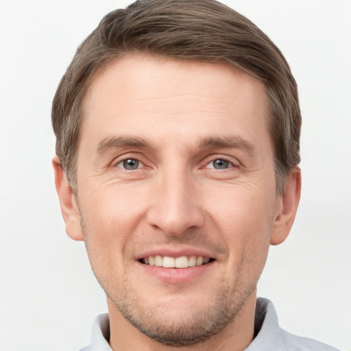 Joyful white young-adult male with short  brown hair and grey eyes