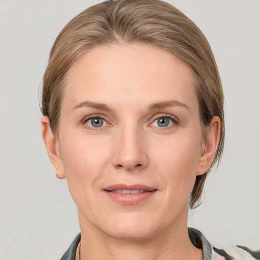 Joyful white adult female with medium  brown hair and grey eyes