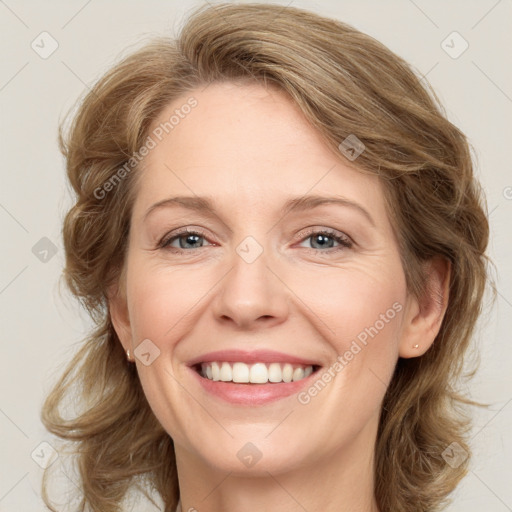 Joyful white adult female with medium  brown hair and blue eyes