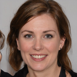 Joyful white adult female with medium  brown hair and brown eyes