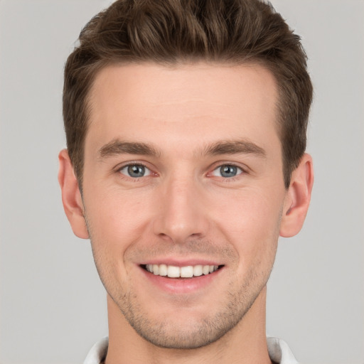 Joyful white young-adult male with short  brown hair and grey eyes