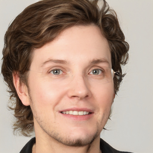 Joyful white young-adult male with medium  brown hair and grey eyes