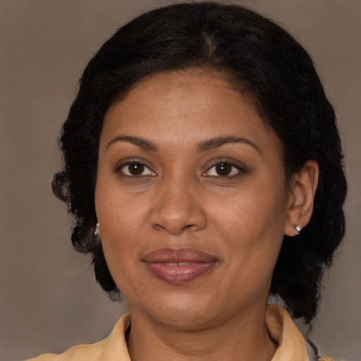 Joyful latino adult female with medium  brown hair and brown eyes