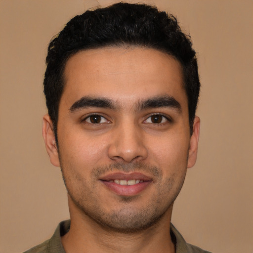 Joyful latino young-adult male with short  black hair and brown eyes