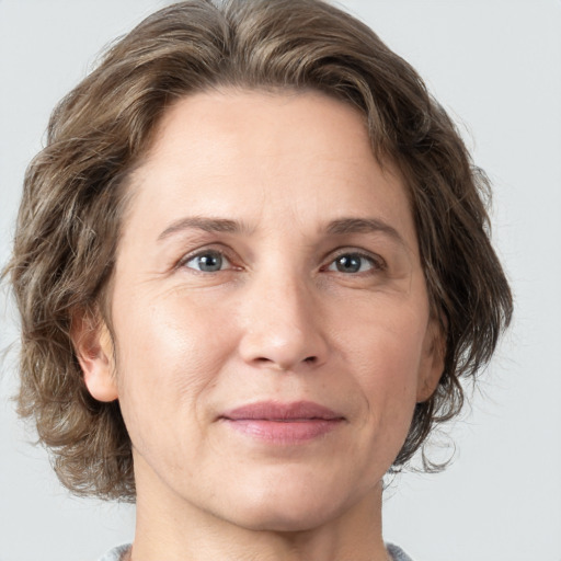 Joyful white adult female with medium  brown hair and grey eyes