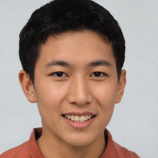 Joyful asian young-adult male with short  brown hair and brown eyes