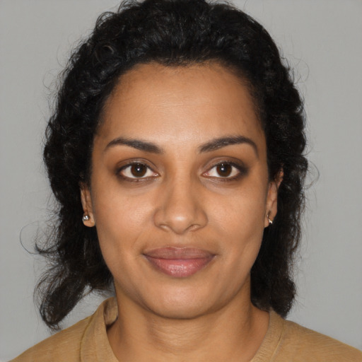 Joyful black young-adult female with long  black hair and brown eyes