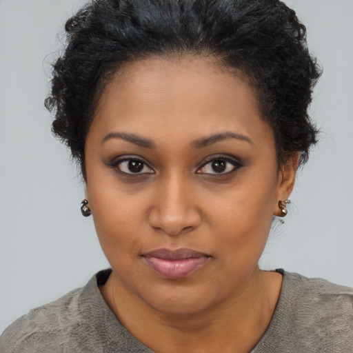 Joyful black young-adult female with short  brown hair and brown eyes