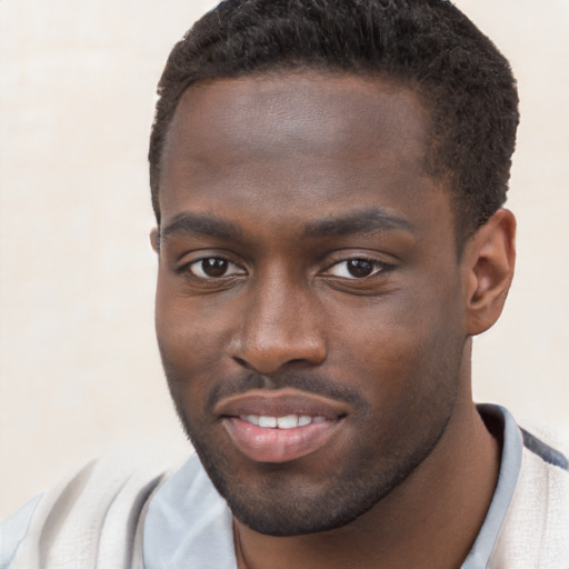 Joyful black young-adult male with short  brown hair and brown eyes