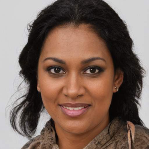 Joyful black young-adult female with long  brown hair and brown eyes
