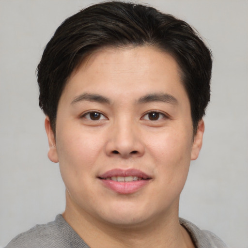 Joyful asian young-adult male with short  brown hair and brown eyes