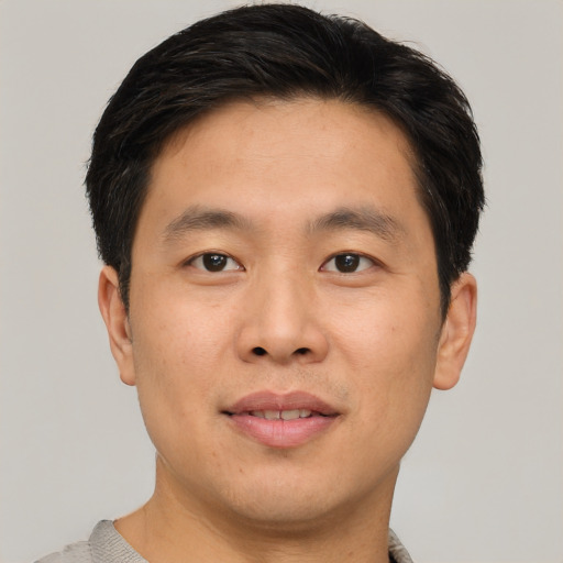 Joyful asian young-adult male with short  brown hair and brown eyes