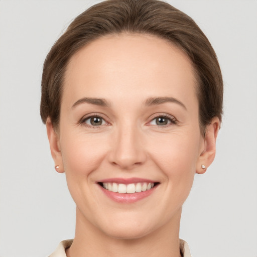 Joyful white young-adult female with short  brown hair and grey eyes