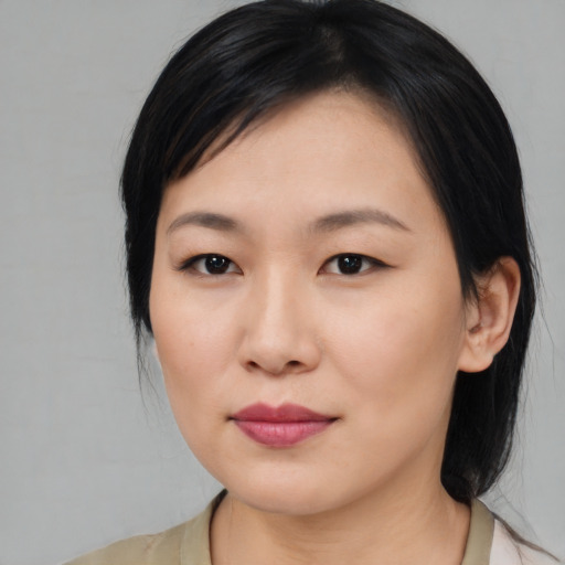 Joyful asian young-adult female with medium  black hair and brown eyes