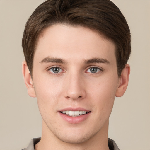 Joyful white young-adult male with short  brown hair and grey eyes