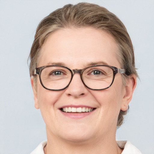 Joyful white adult female with medium  brown hair and blue eyes