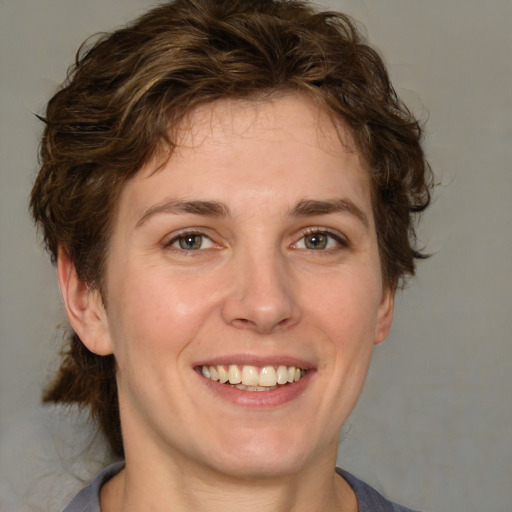 Joyful white young-adult female with medium  brown hair and green eyes