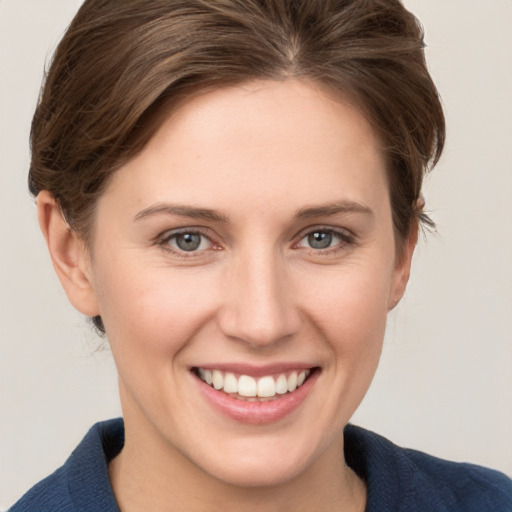 Joyful white young-adult female with medium  brown hair and grey eyes