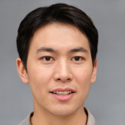 Joyful asian young-adult male with short  brown hair and brown eyes