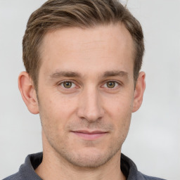 Joyful white young-adult male with short  brown hair and grey eyes