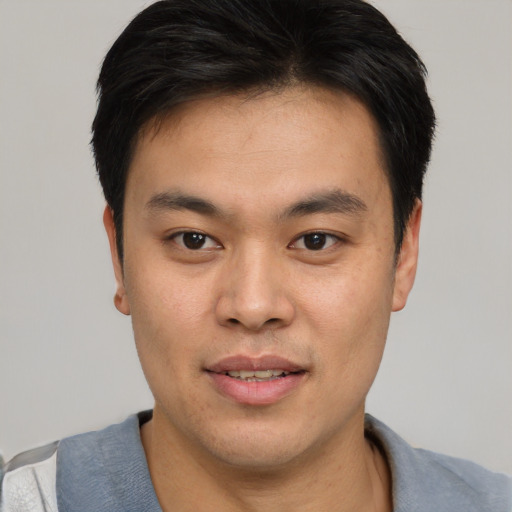 Joyful asian young-adult male with short  brown hair and brown eyes