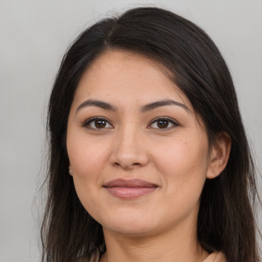 Joyful latino young-adult female with long  brown hair and brown eyes