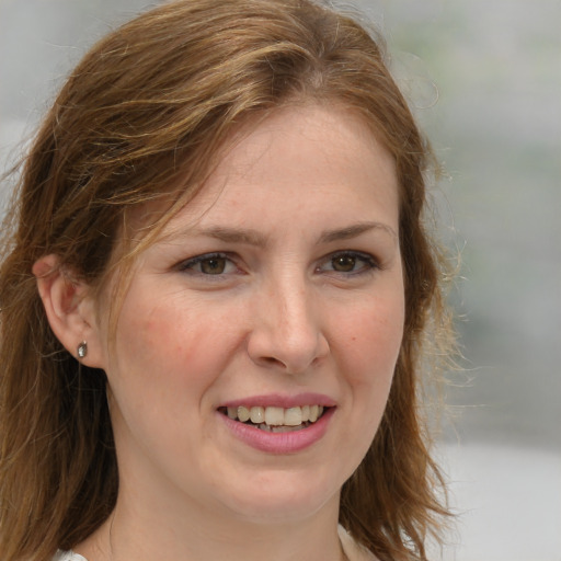 Joyful white young-adult female with medium  brown hair and blue eyes