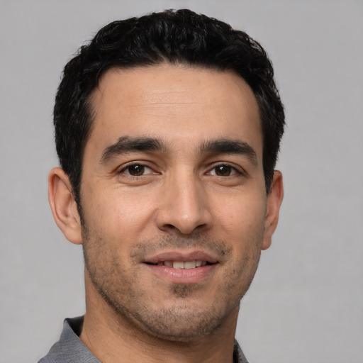 Joyful white young-adult male with short  black hair and brown eyes